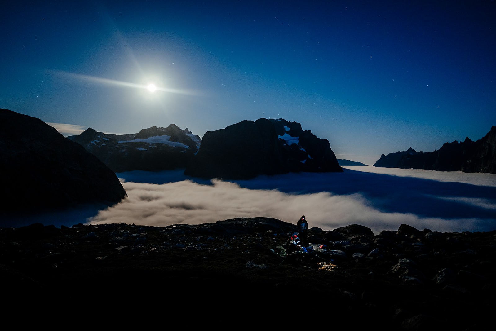 group of travelers at camping ground high above sea level at night on Greenland