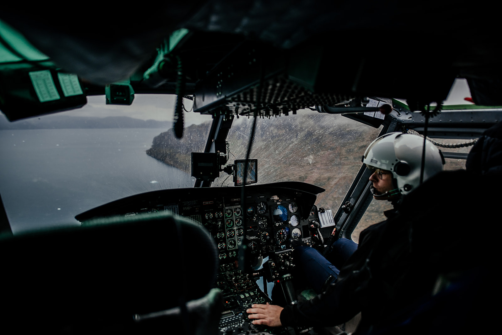 inside view of helicopter cockpit while flying on Greenland