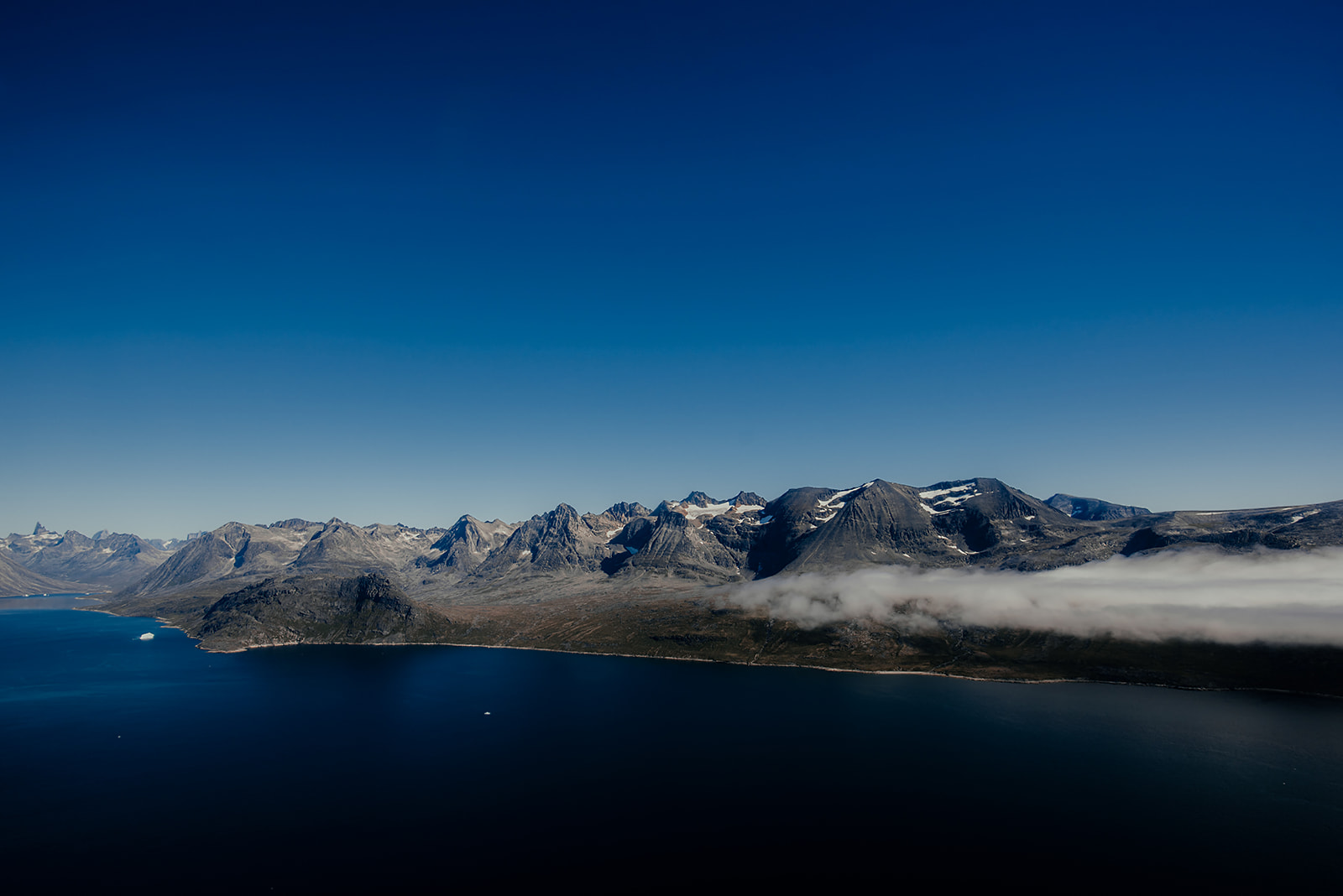 mountain range under blue sky on Greenland