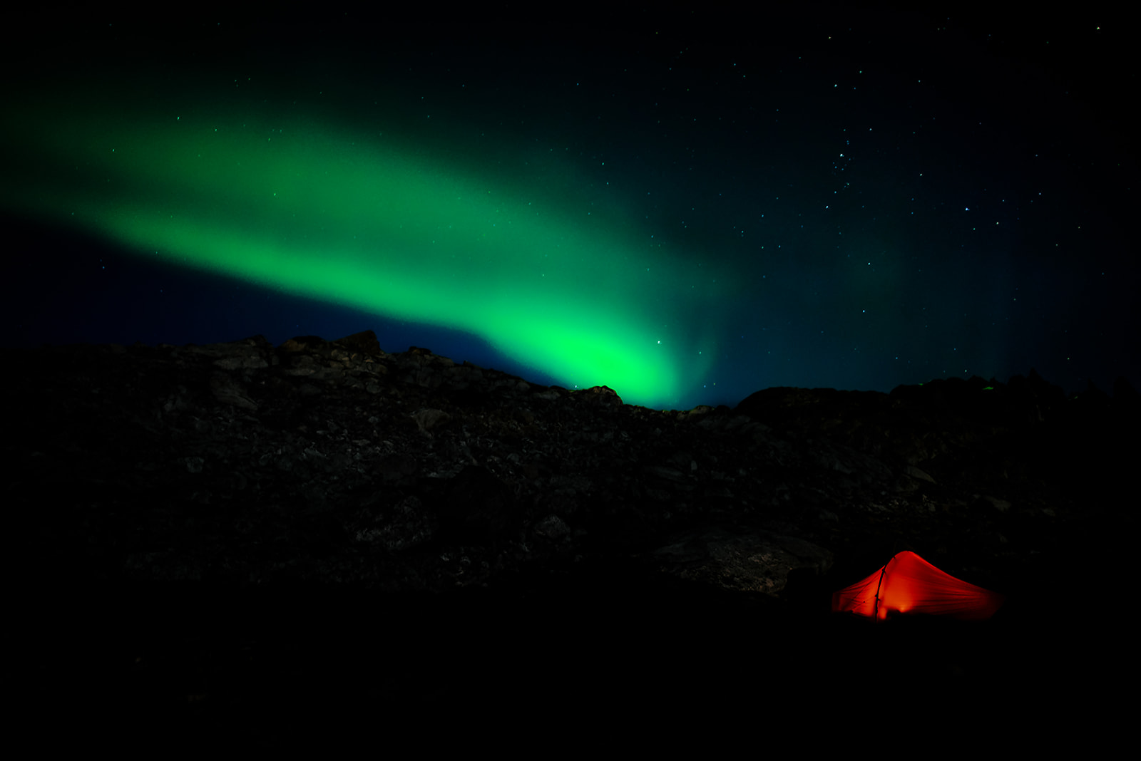 northern lights over a red tent on Greenland