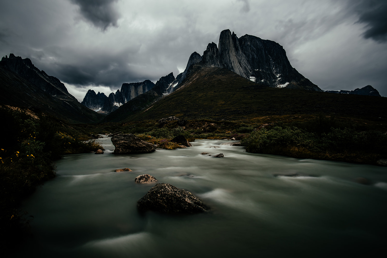 a river in front of a mountain range on Greenland