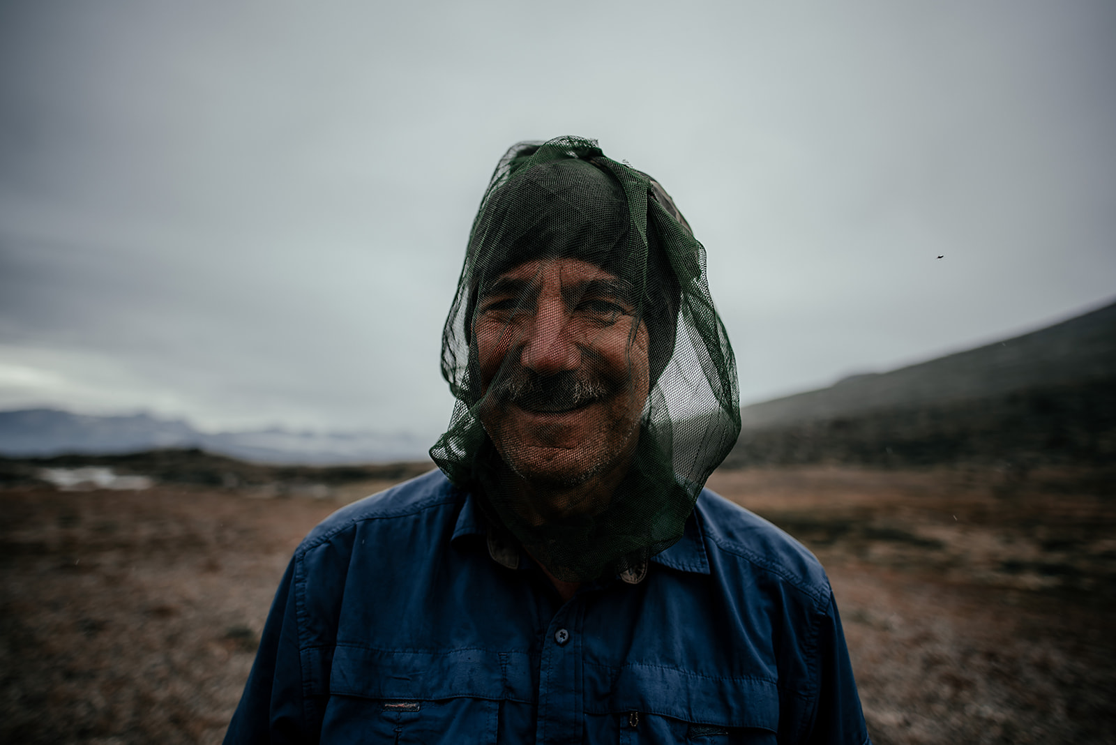 traveler with mosquito net over his head on Greenland