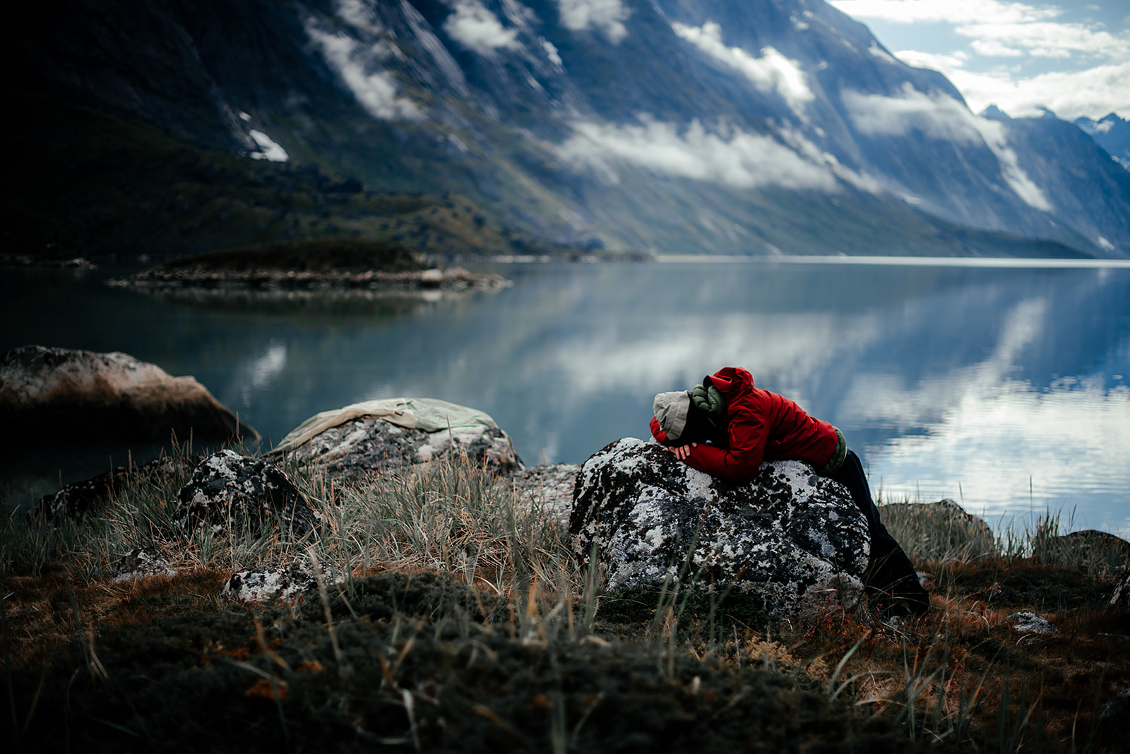 traveler sleeping on rock on Greenland