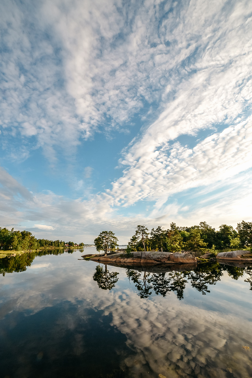 calm bay of a Swedish archipelago mirroring the sky