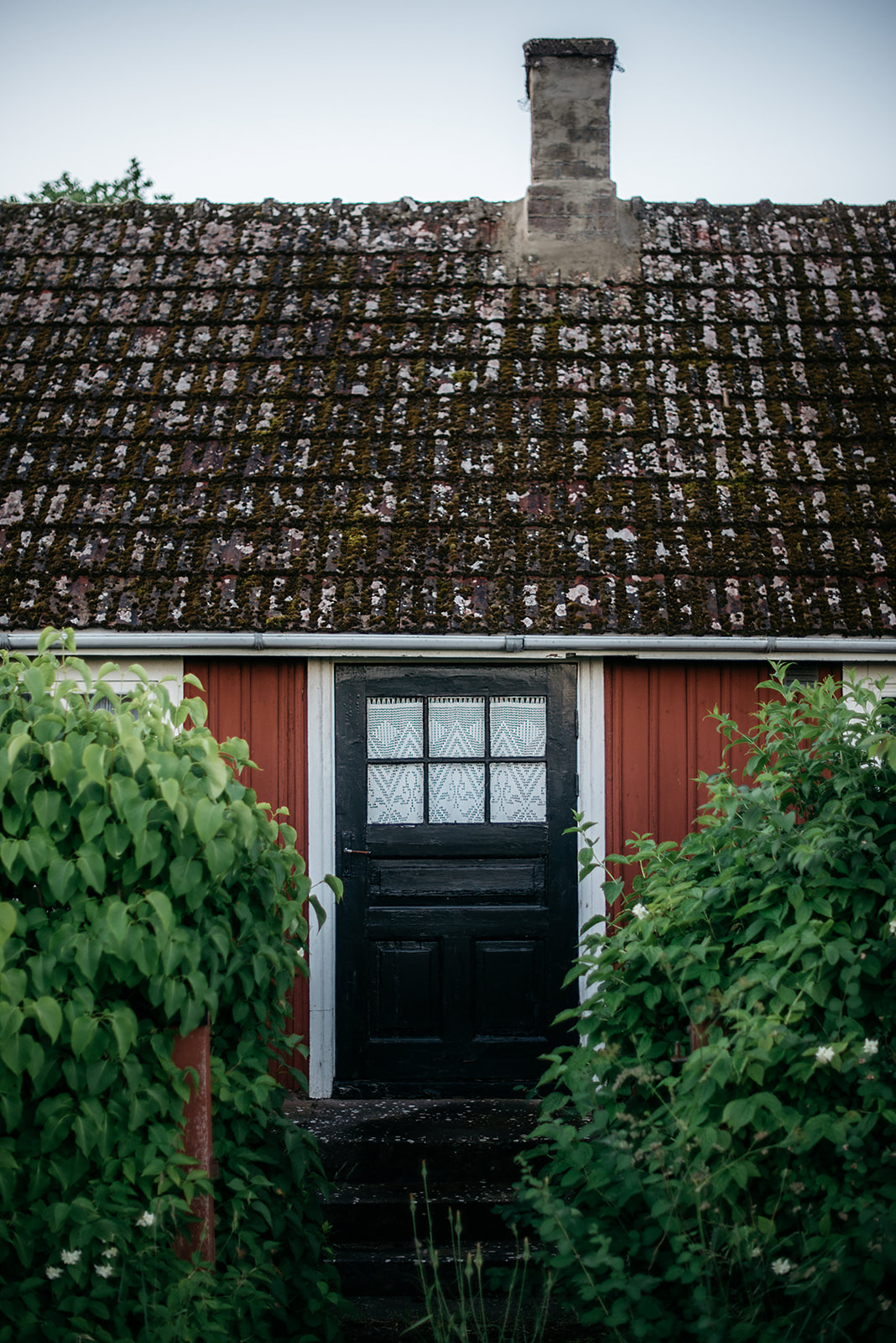 tiny wooden red painted house with black door in Sweden