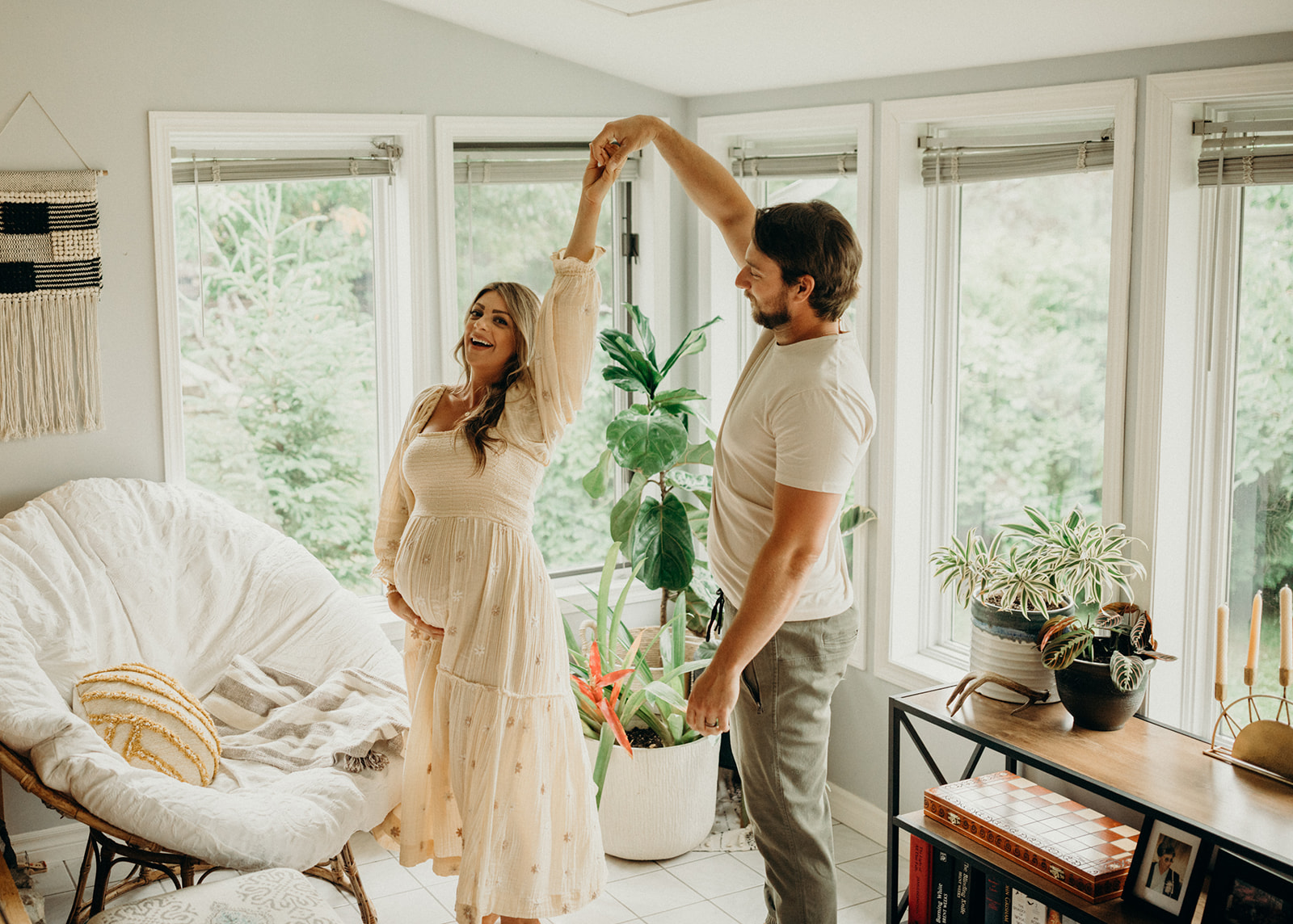 Couple dances in the living room during their maternity photoshoot in Thunder Bay 