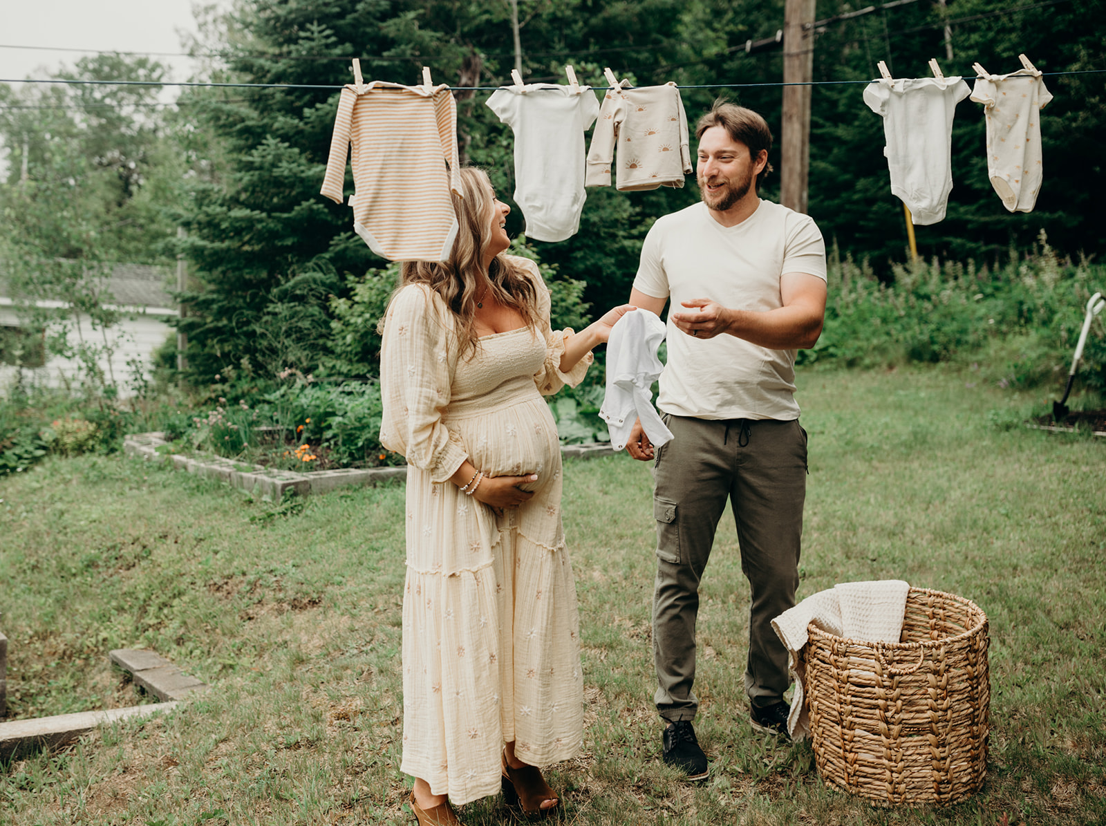 Couple hangs clothes on the line during their maternity photoshoot in Thunder Bay