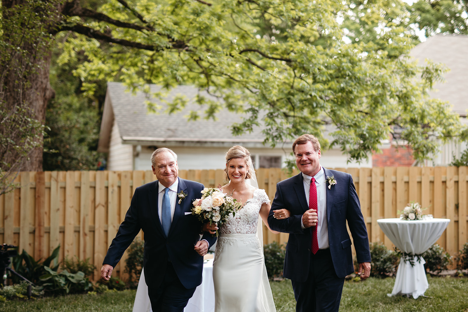 Bride walking down the aisle with her two dads