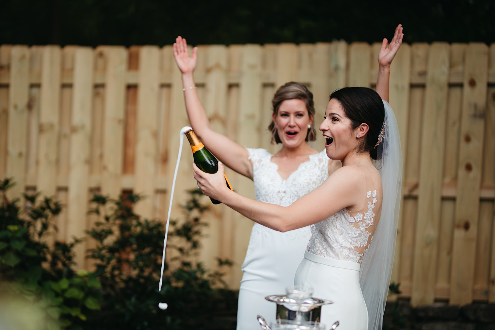 queer couple pops champagne on their wedding day