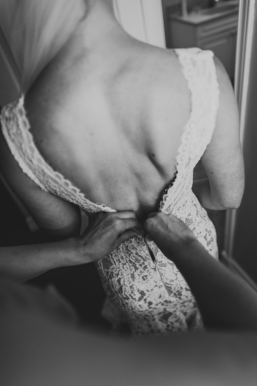 Black and white image of the back of bride's dress