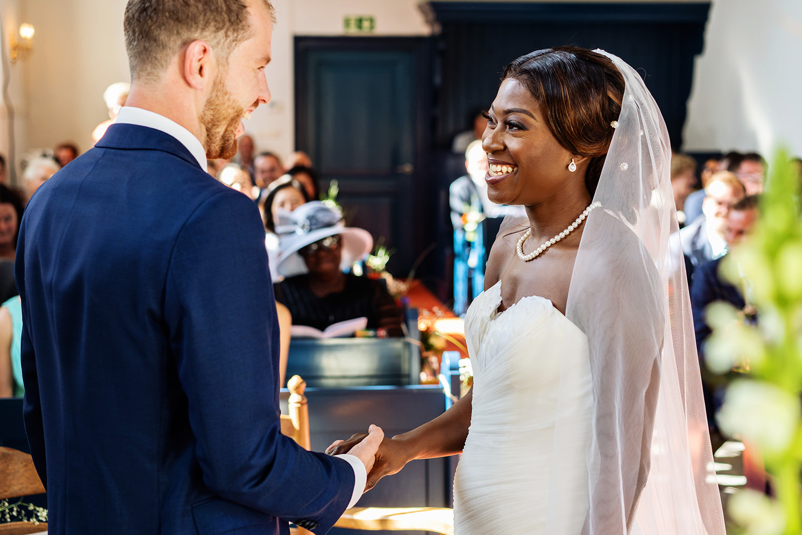 Bruid en bruidegom geven elkaar het jawoord. Multiculturele bruiloft. Nederlands-Afrikaanse bruiloft