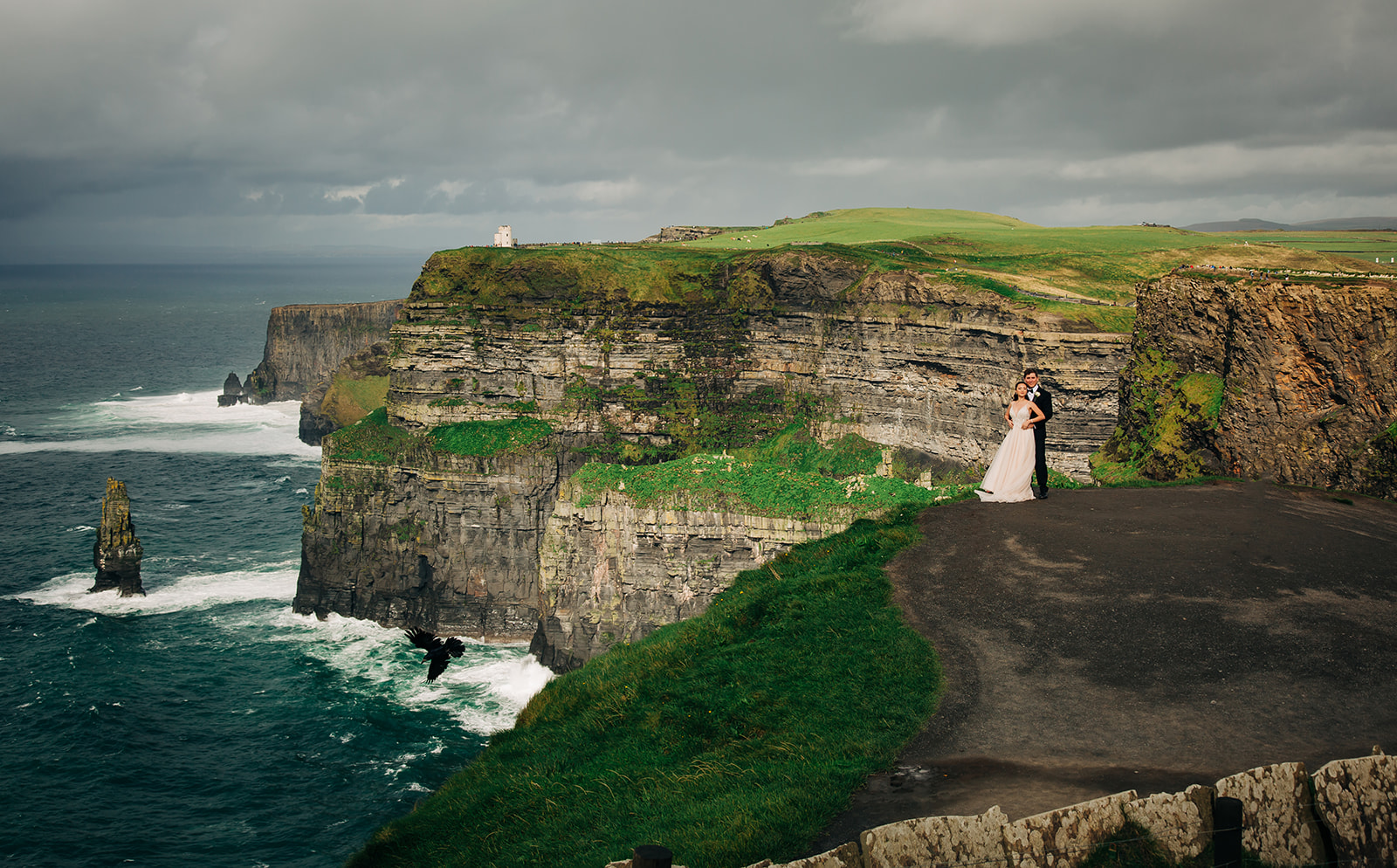Bride and groom posting at the cliffs of Moher