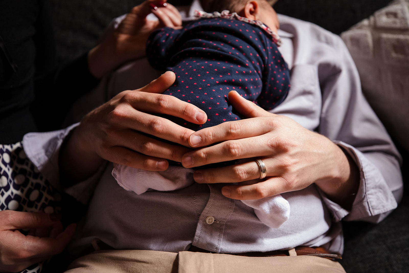 close of newborn baby in fathers hands