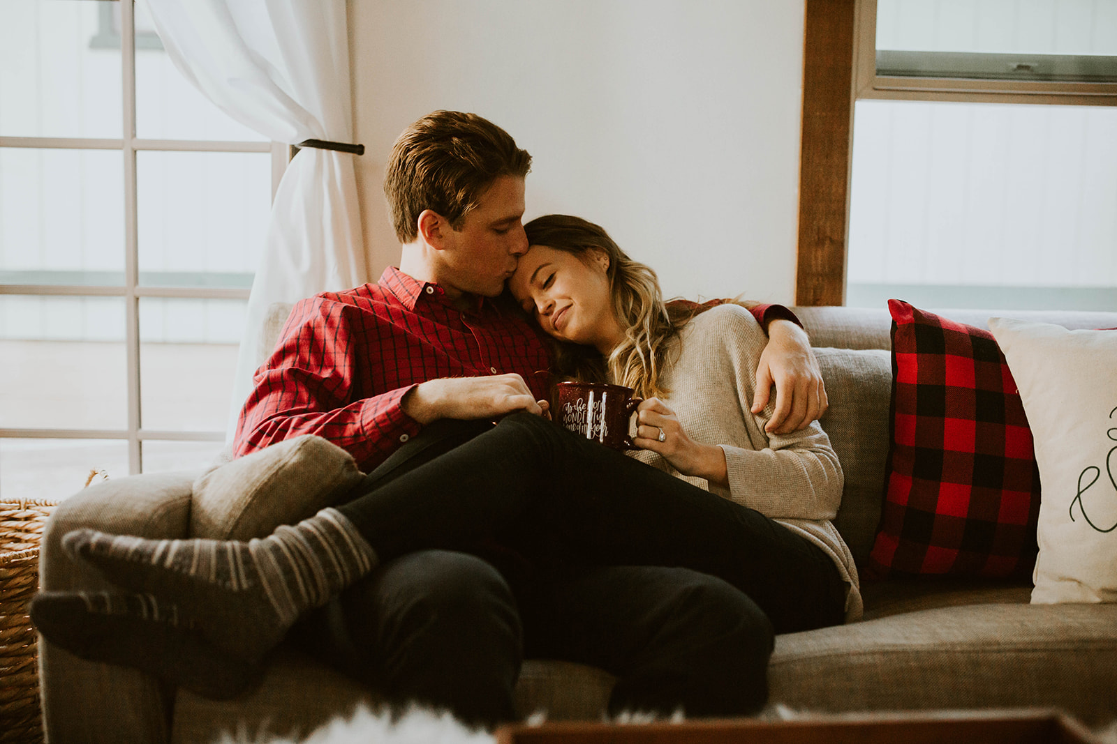couple snuggles at Christmas engagement session