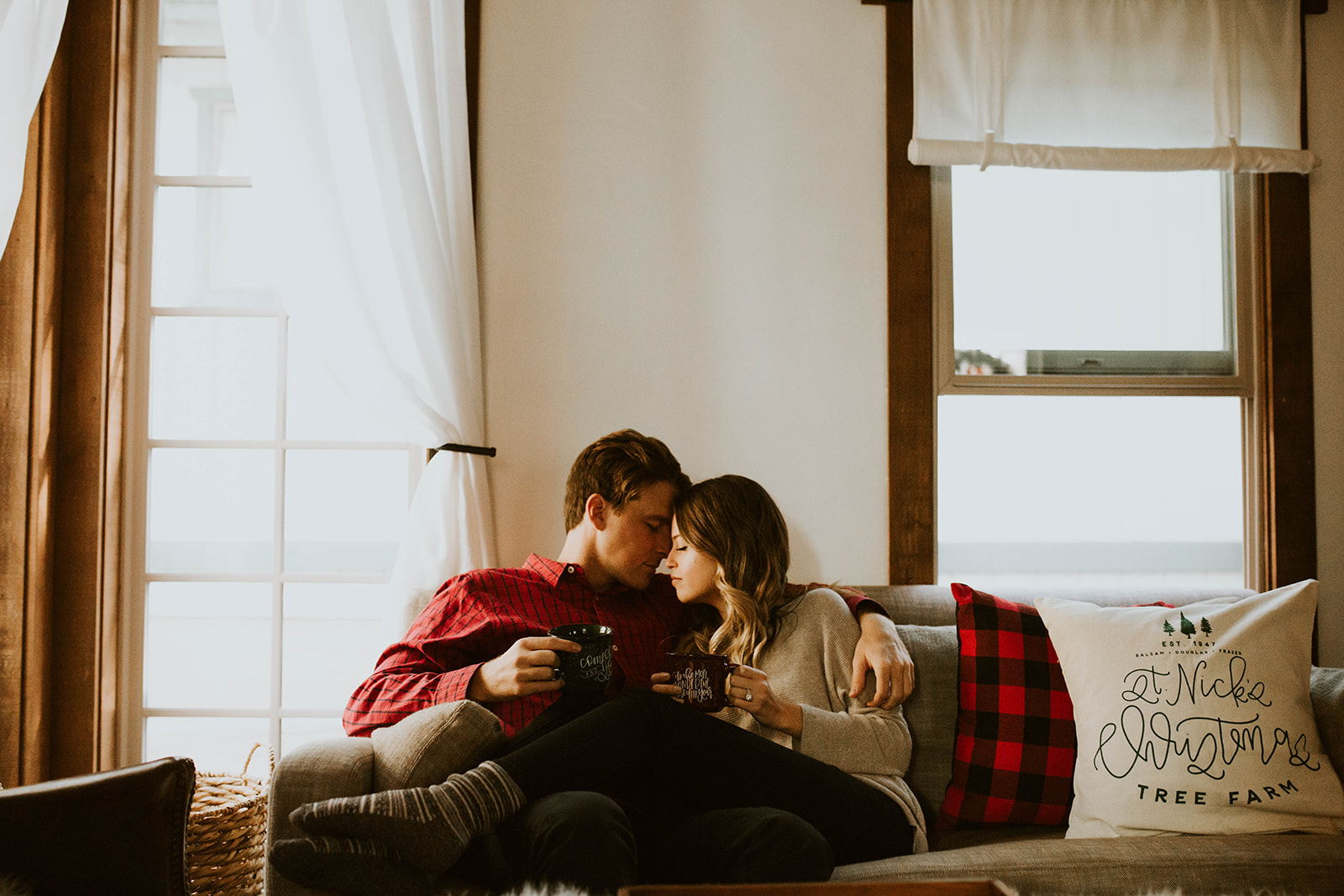 couple snuggles at Christmas engagement session