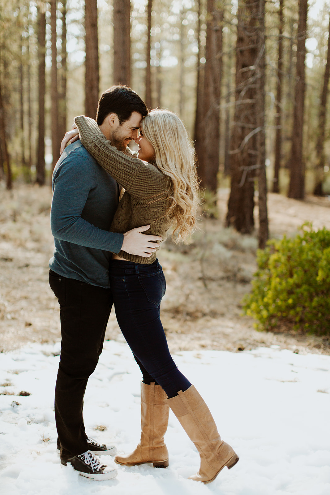 couple has fun in snow at San Bernardino forest Big Bear engagement session