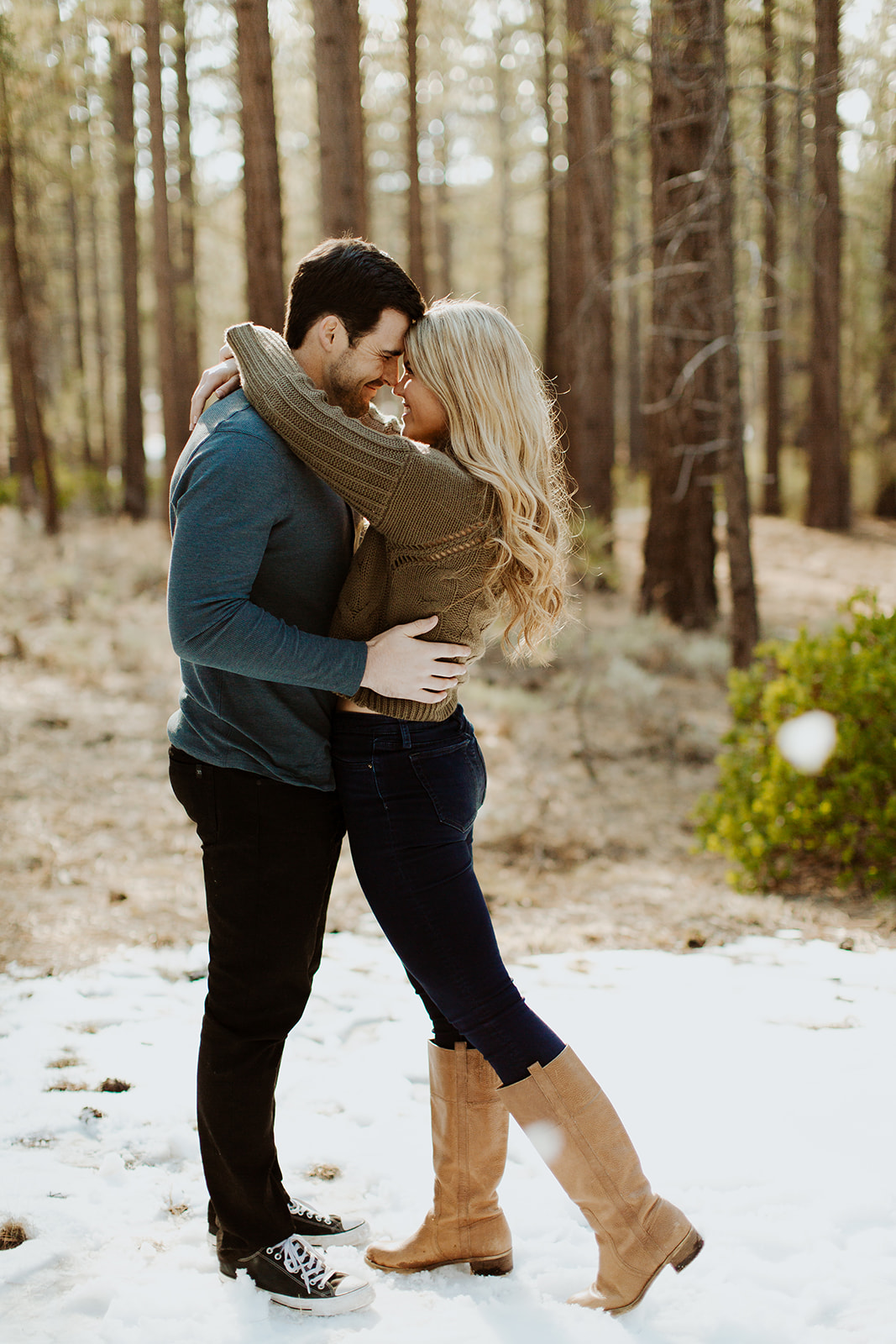 couple has fun in snow at San Bernardino forest Big Bear engagement session