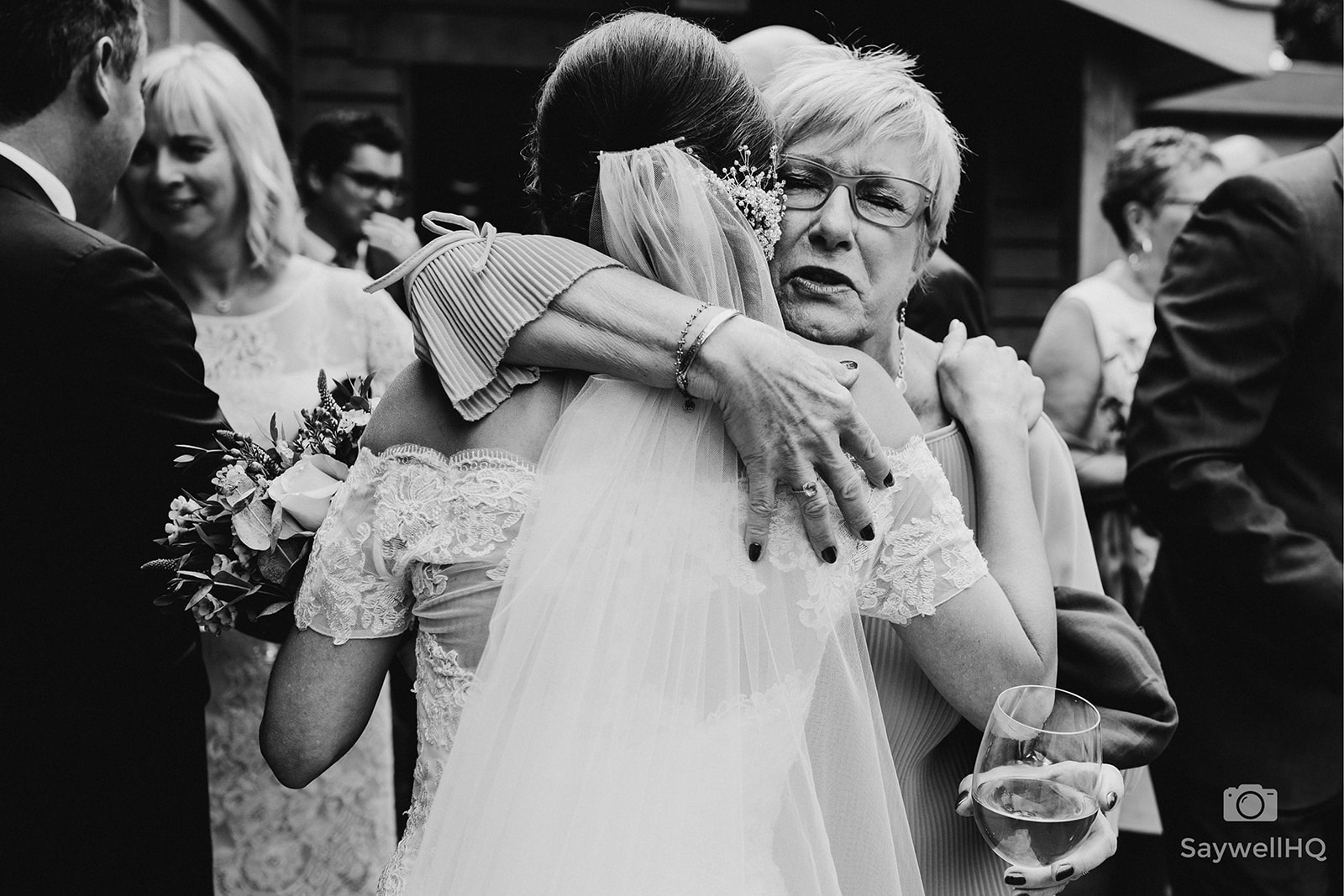 The Chequers Inn Wedding Photography - a wedding guest hugging the bride