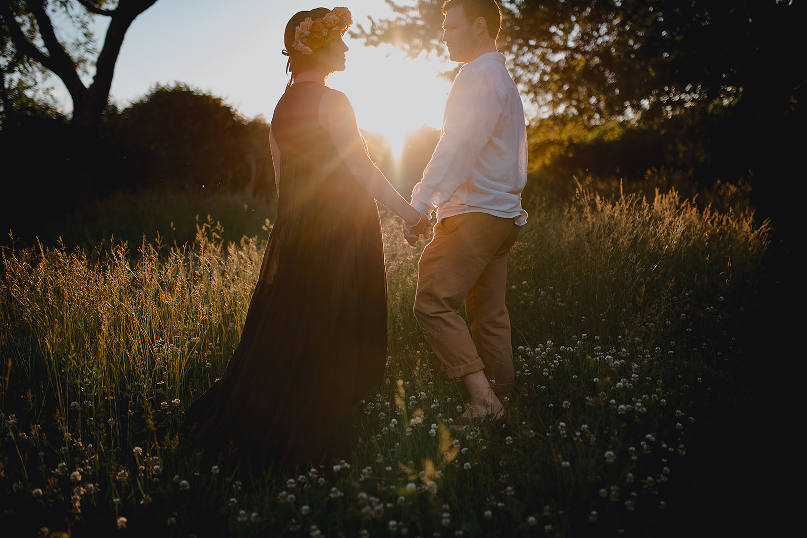 Silhouettes of newlyweds at dusk in a wildflower field, radiating romance and tranquility.