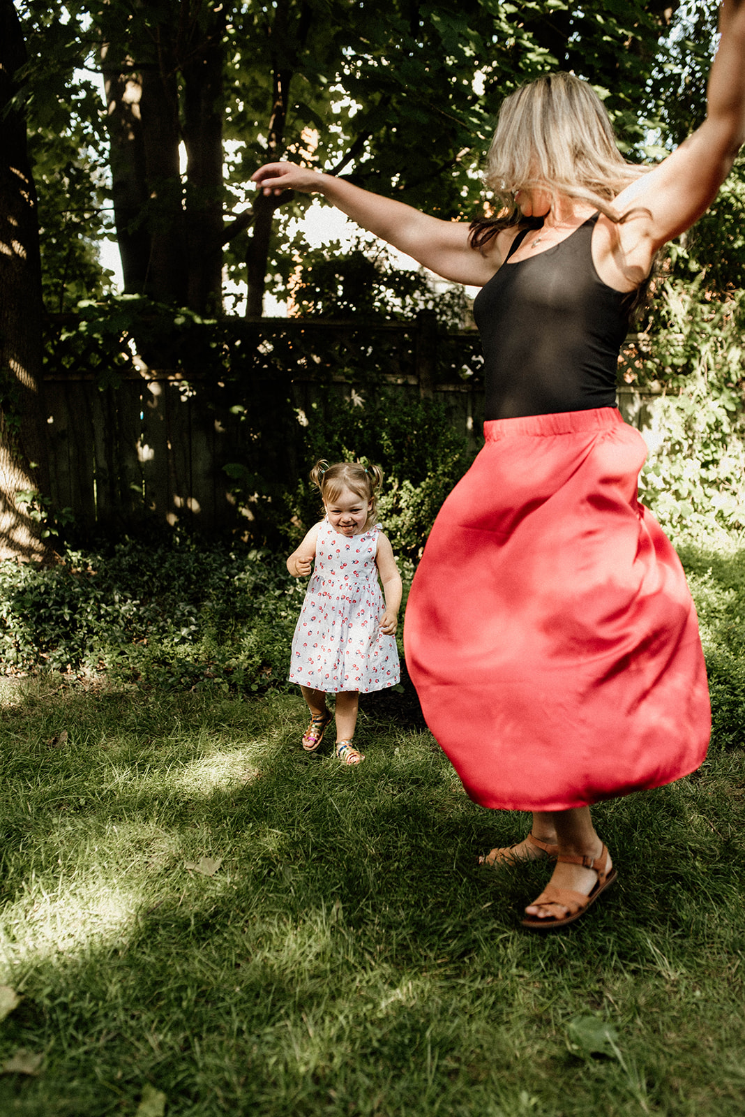 Mommy and daughter dancing in the backyard