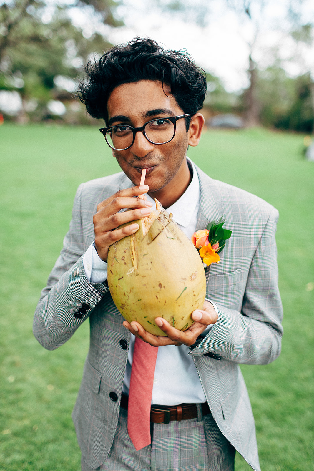 Guy drinking a fresh coconut at a Maui wedding
