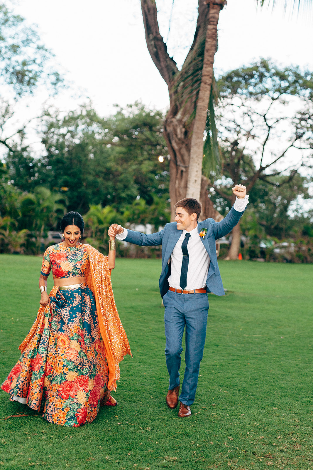 Bride and groom enter their reception in a custom Indian dress