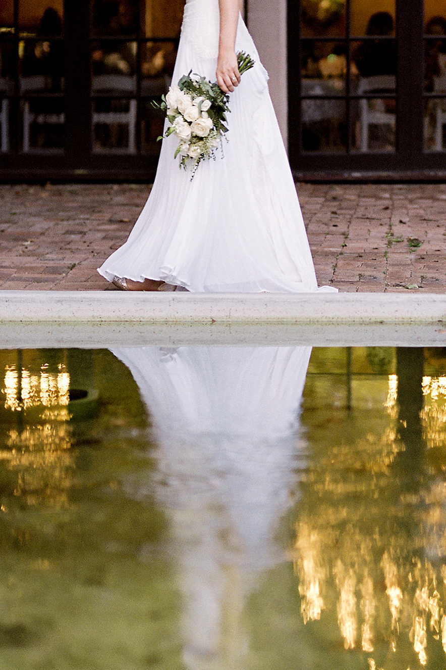 A bride strolls past the fountain outside the Victory Room of the Lewis Clark Hotel on her wedding day.