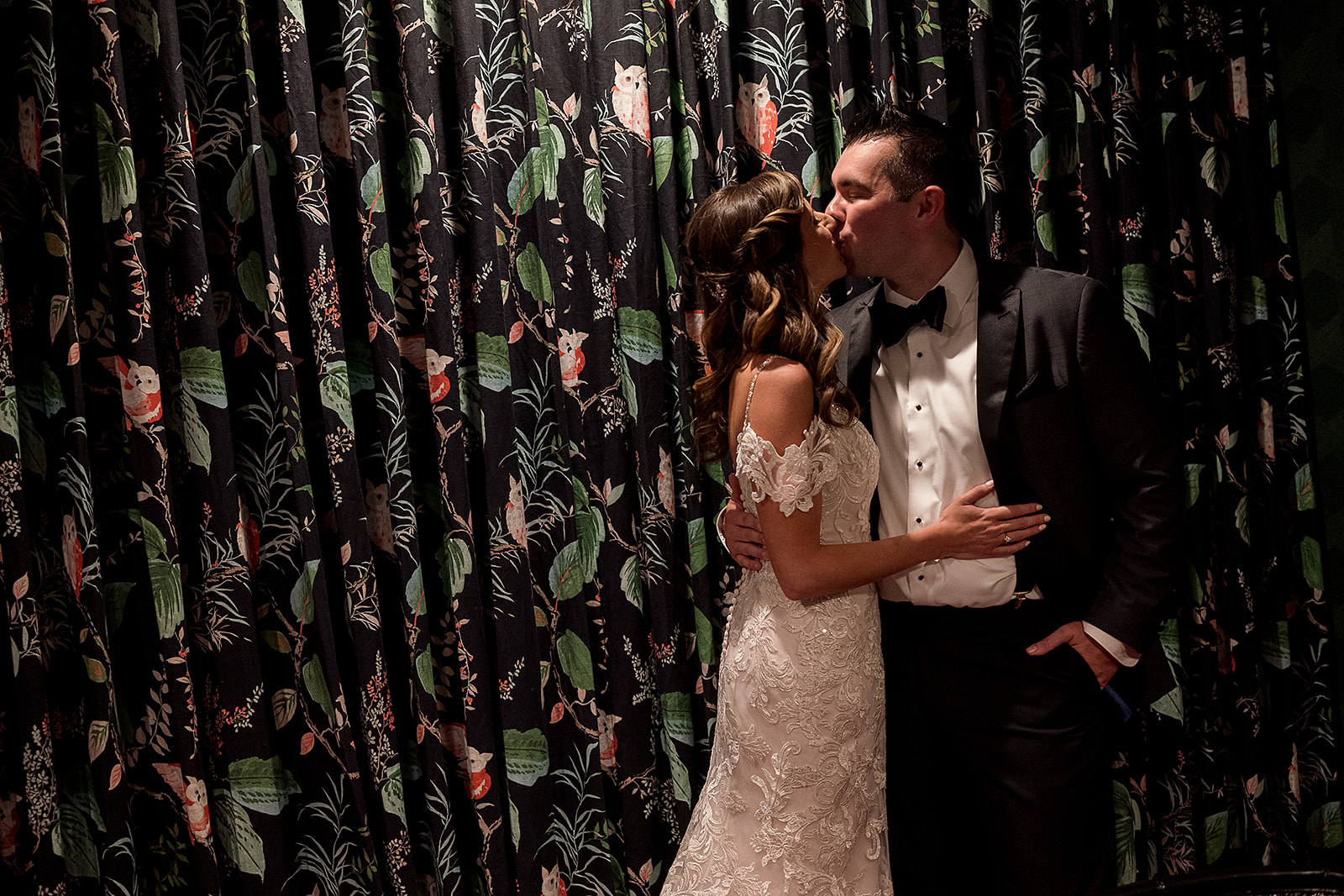bride and groom kissing  with cool wall paper at graduate hotel in Providence Rhode Island 