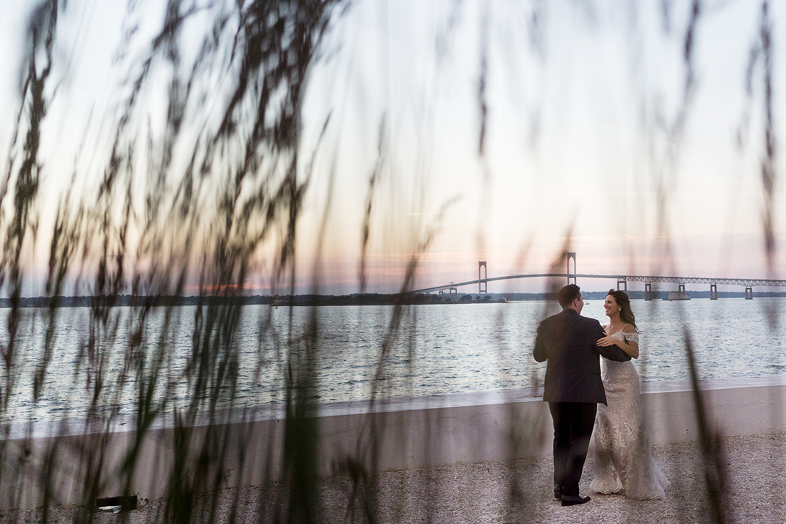 bride and groom practice their first dance at sunset by the waterfront at belle mer