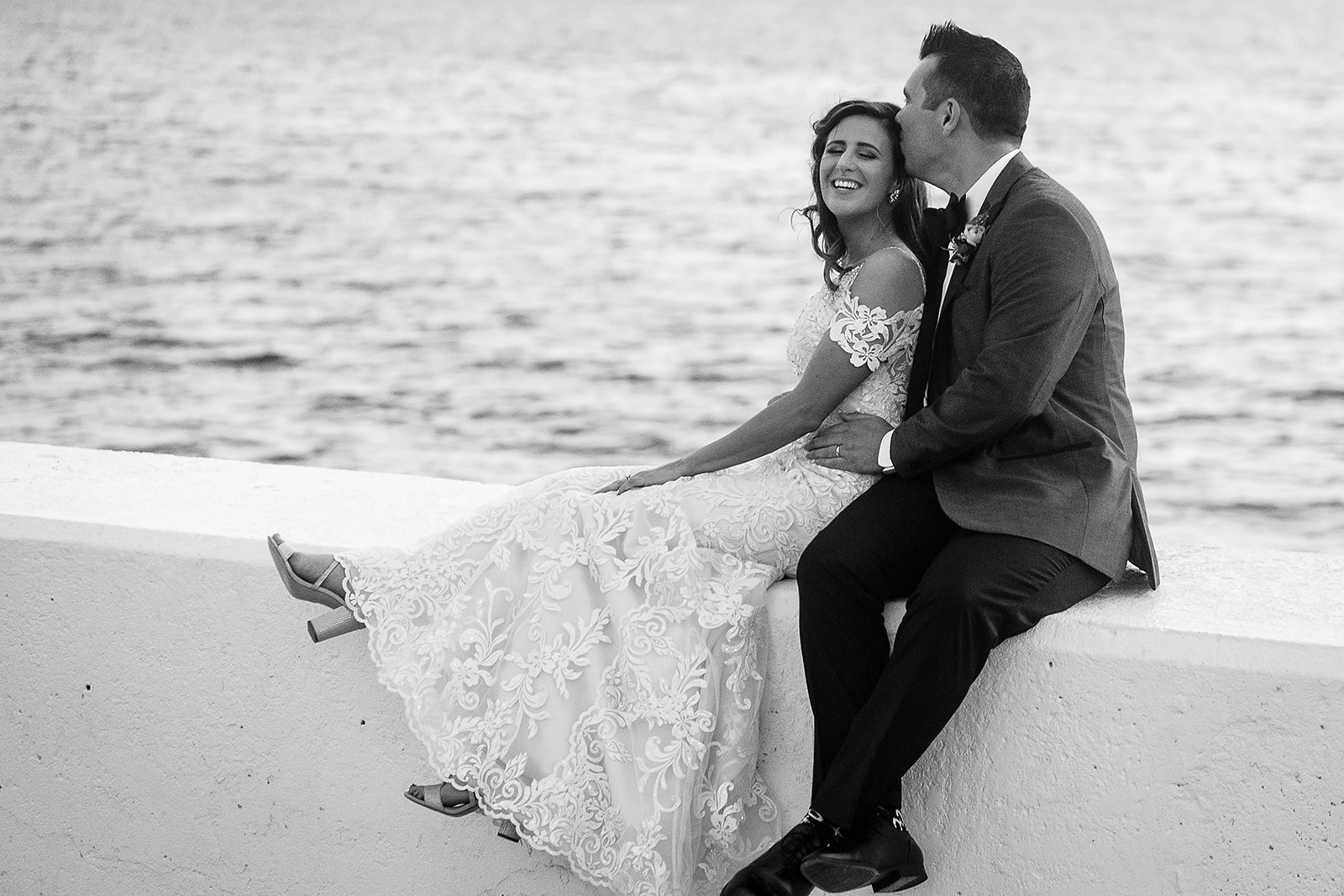 bride and groom sit by the water at Belle Mer in Newport Rhode Island wedding