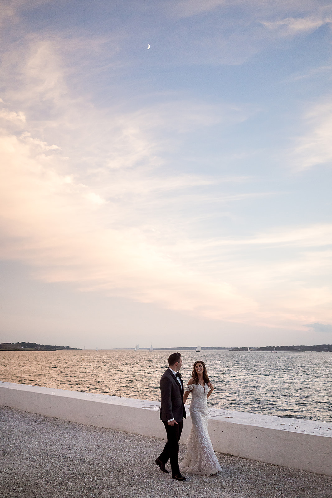 bride and groom sunset portraits along the water at Belle Mer in Newport Rhode Island