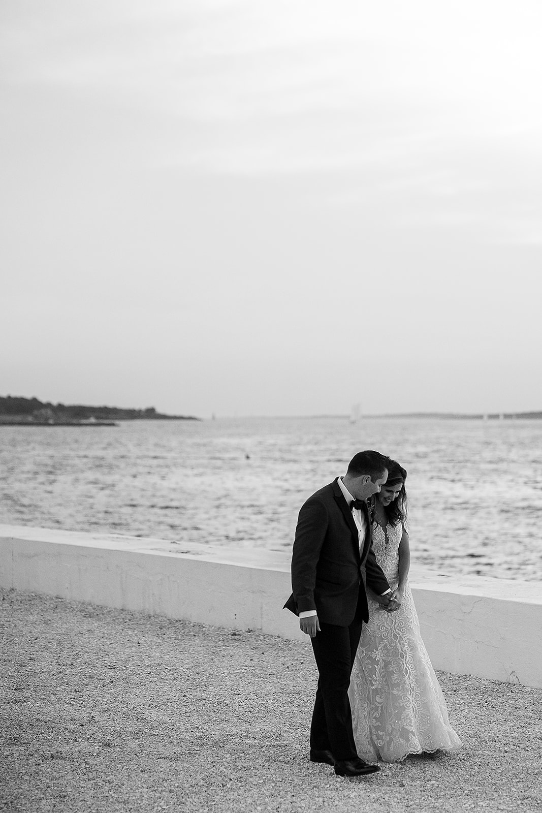 bride and groom walk together on waterfront at belle mer in Newport Rhode Island 