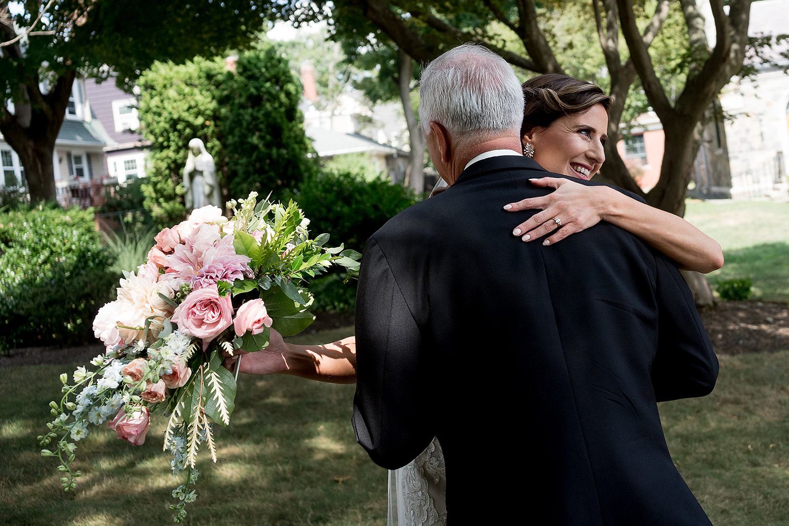 bride hugs family after wedding ceremony at St. Sebastian’s Church in Providence Rhode Island