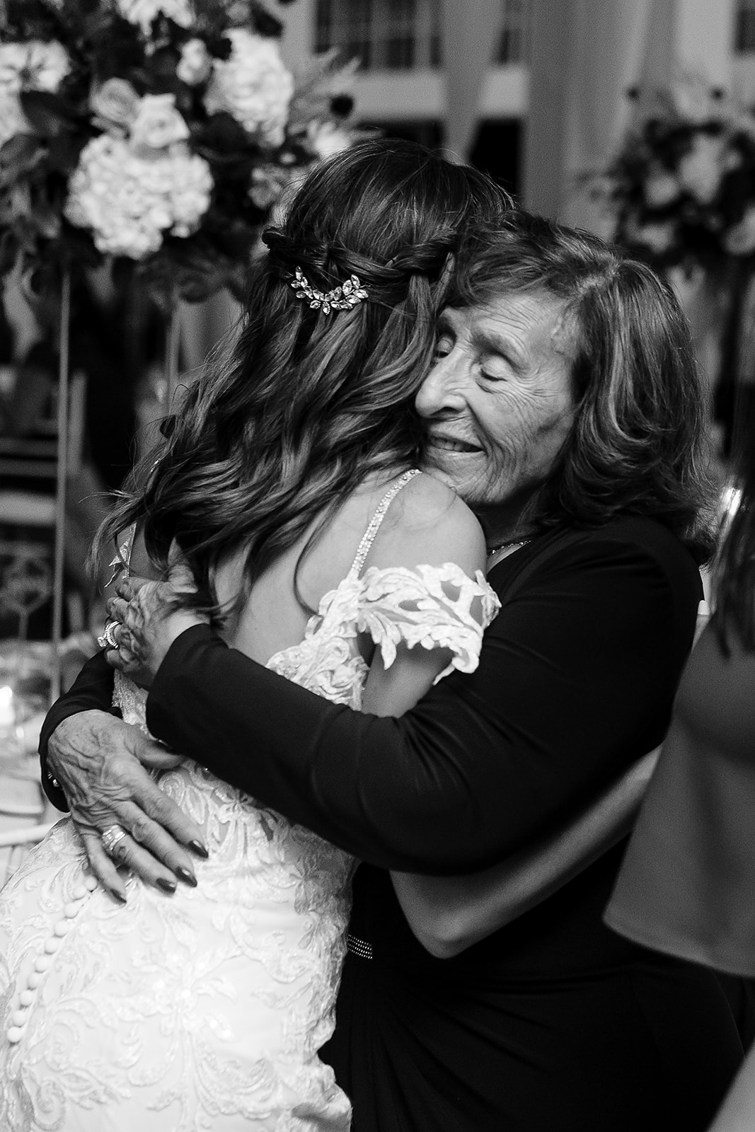 brides grandma hugs bride during belle mer wedding reception 