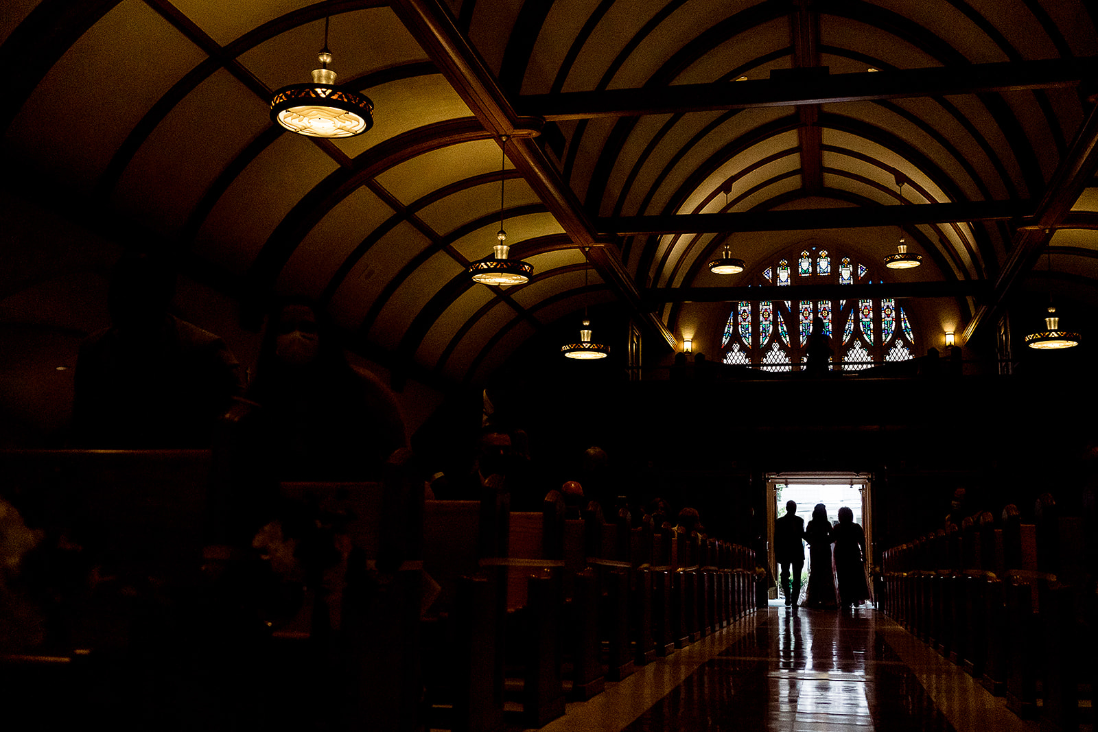 Silhouette of bride with her parents walking down the aisle St. Sebastian’s Church in Providence Rhode Island