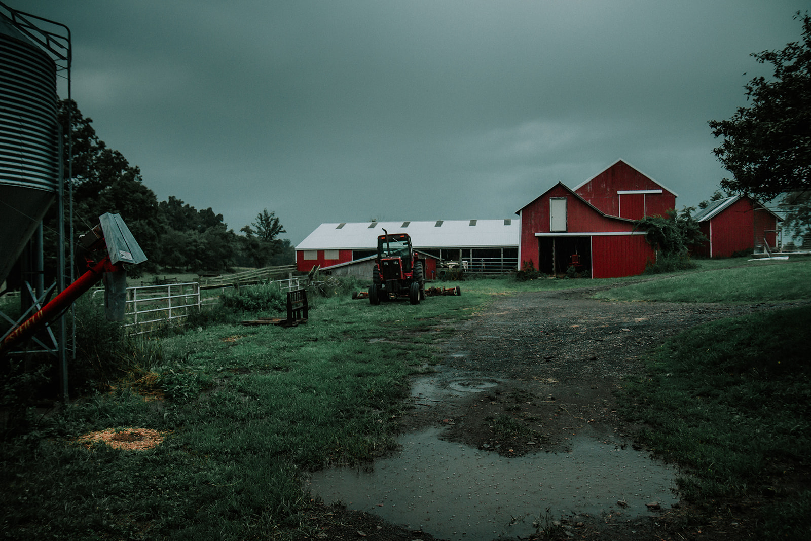photos of a couple session on a farm during a summer rain storm