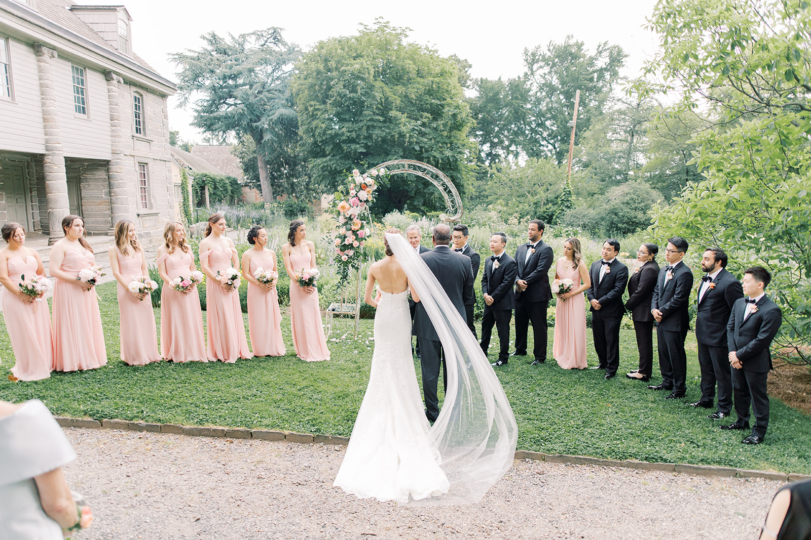 bride walks down the aisle for peachy spring wedding at Bartram's Garden in Philadelphia