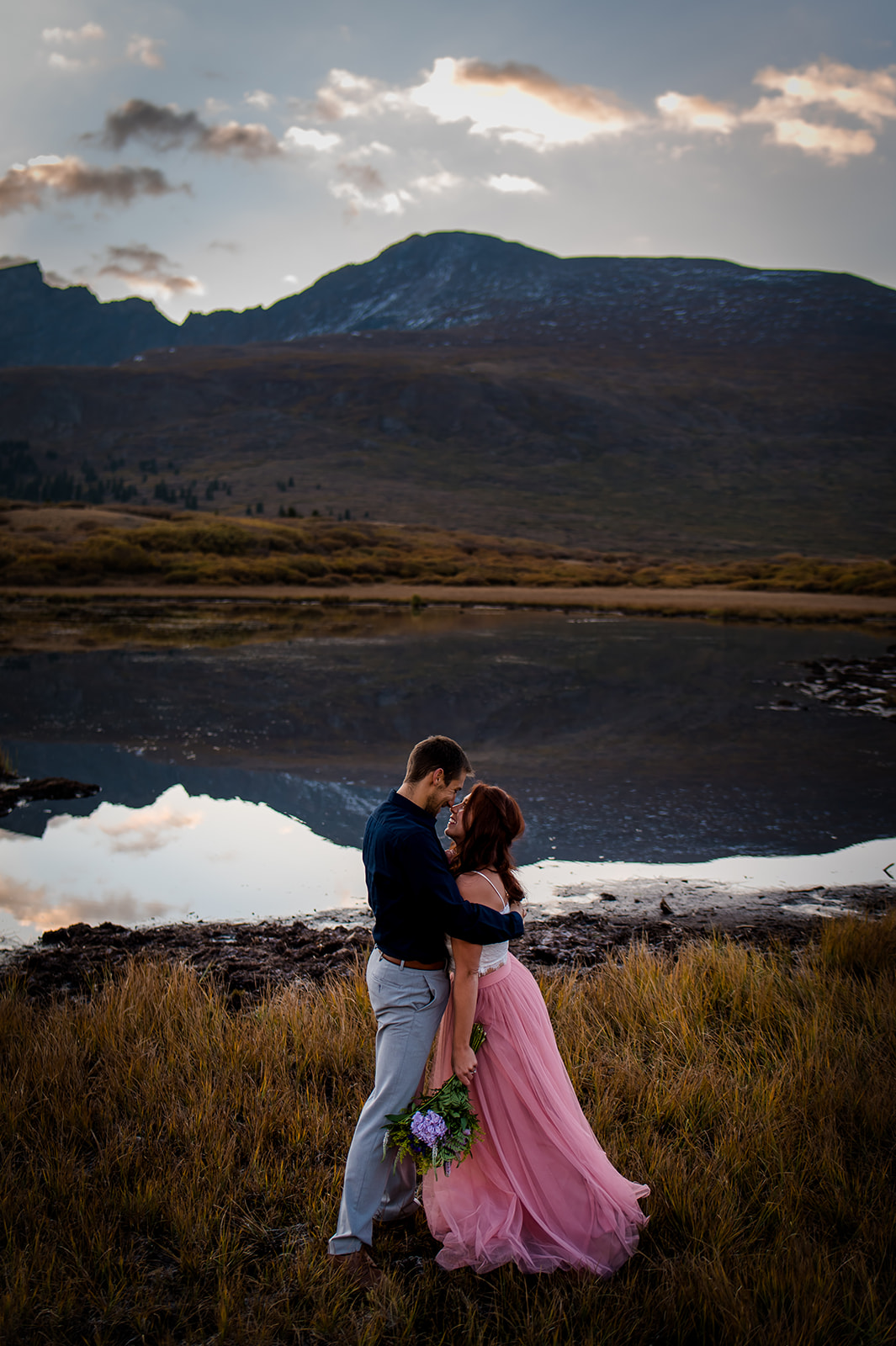 a couple embraces during a cold fall sunrise up on Guanella Pass in Colorado for their adventure engagement photography 