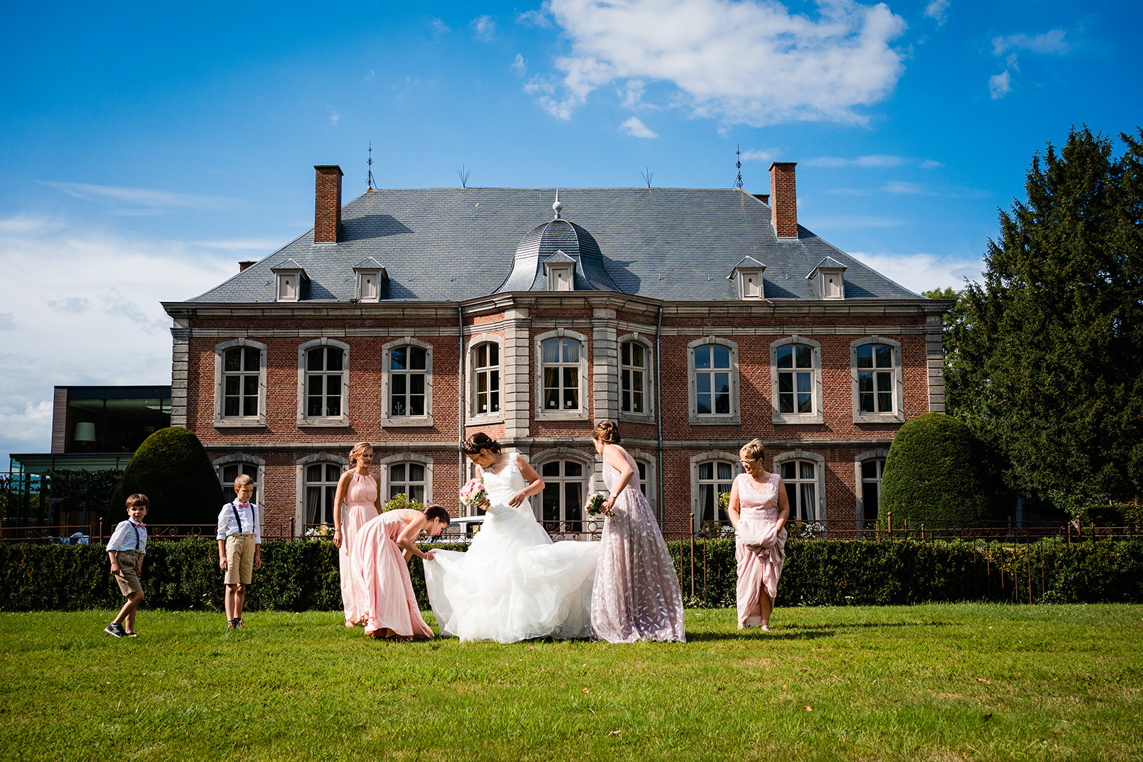 La mariée accompagnée de ses demoiselles d'honneurs dans les jardin du château de Wanfercée à Fleurus