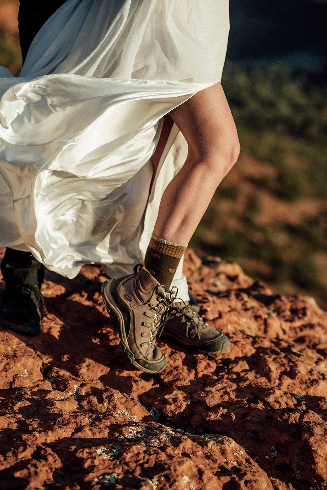 bride in hiking boots with her white wedding dress