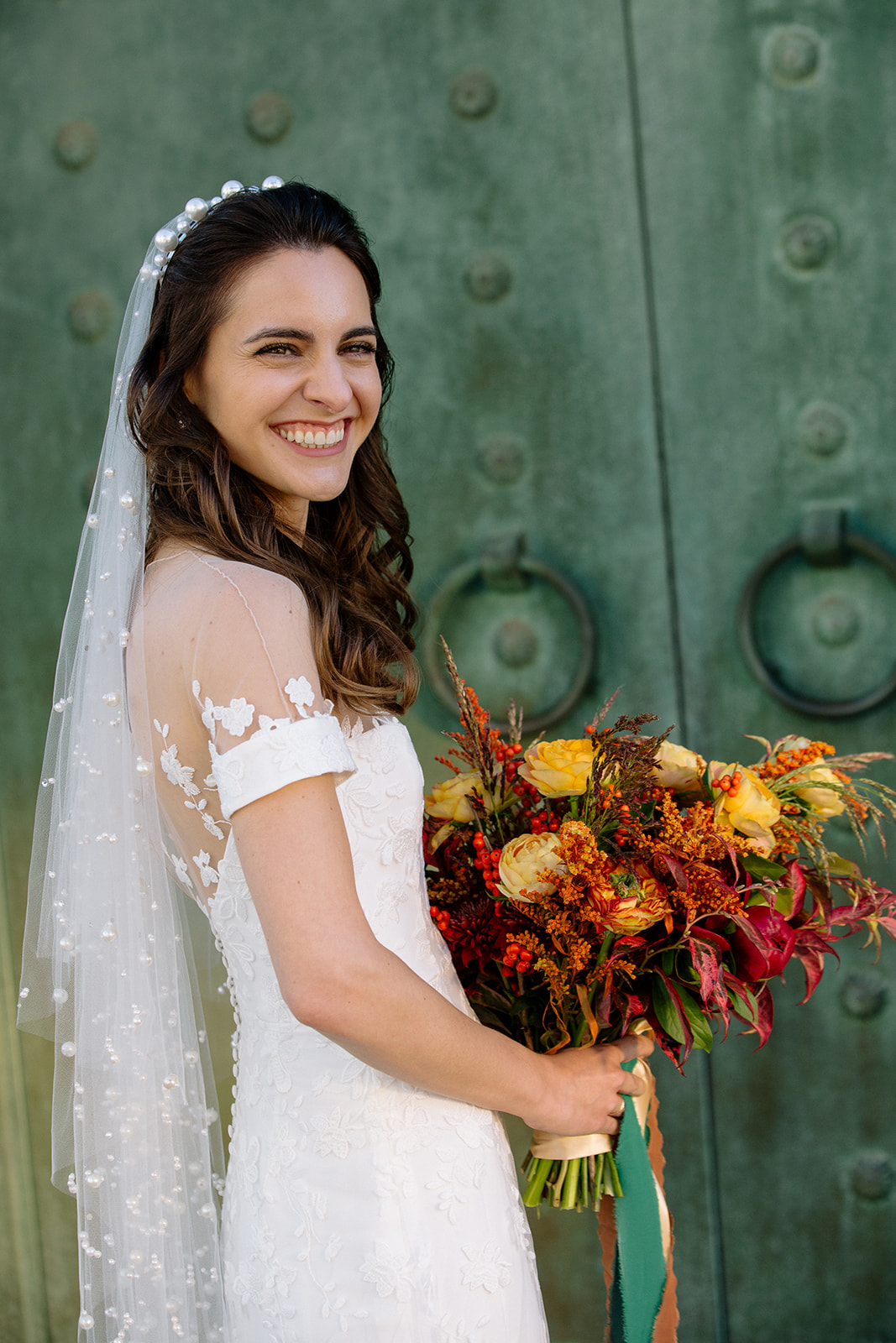 Bride with veil and fall a colored bouquet
