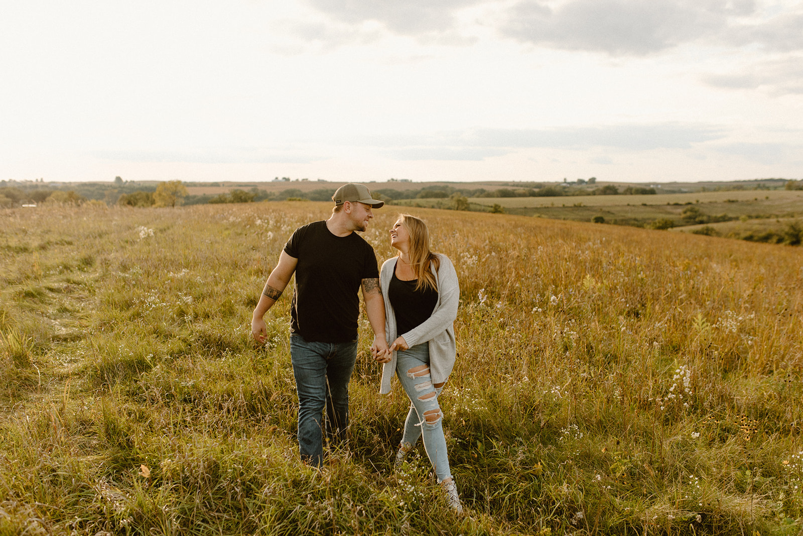 a couple in a grassy field at golden hour running during a photo session