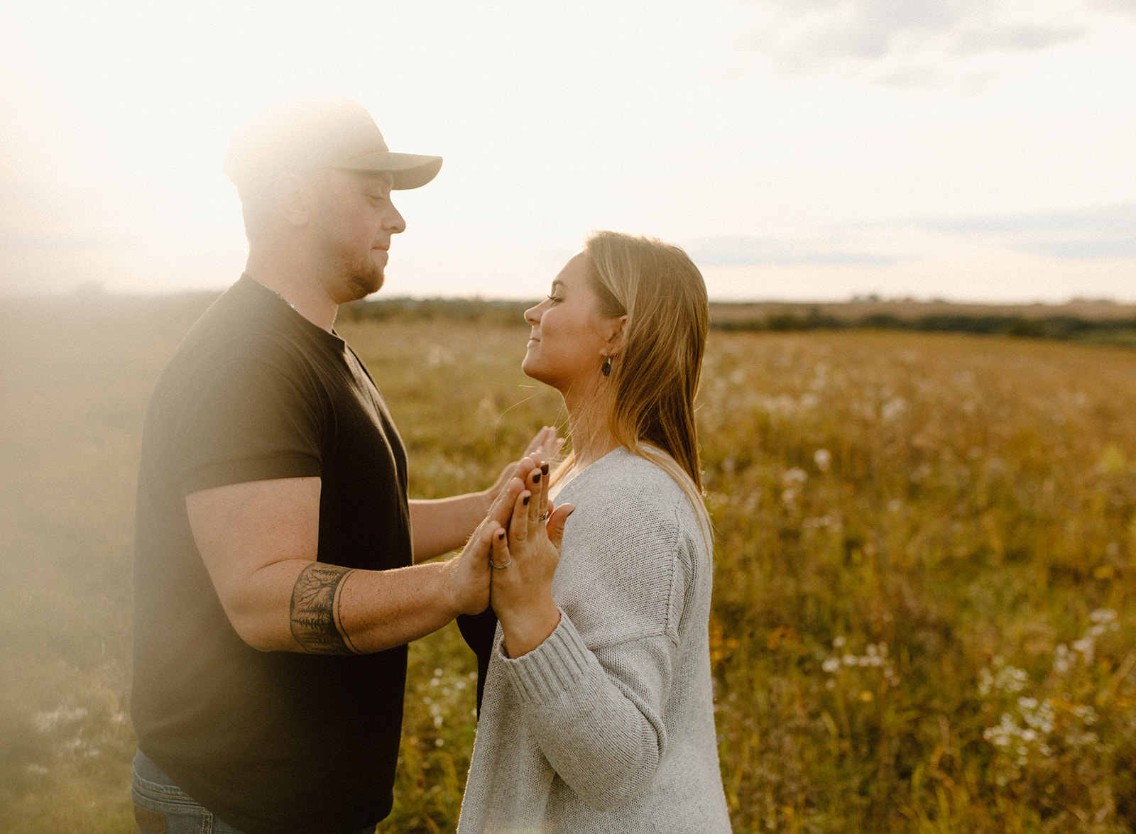 a couple in a grassy field at golden hour during a photo session in barneveld, wisconsin 