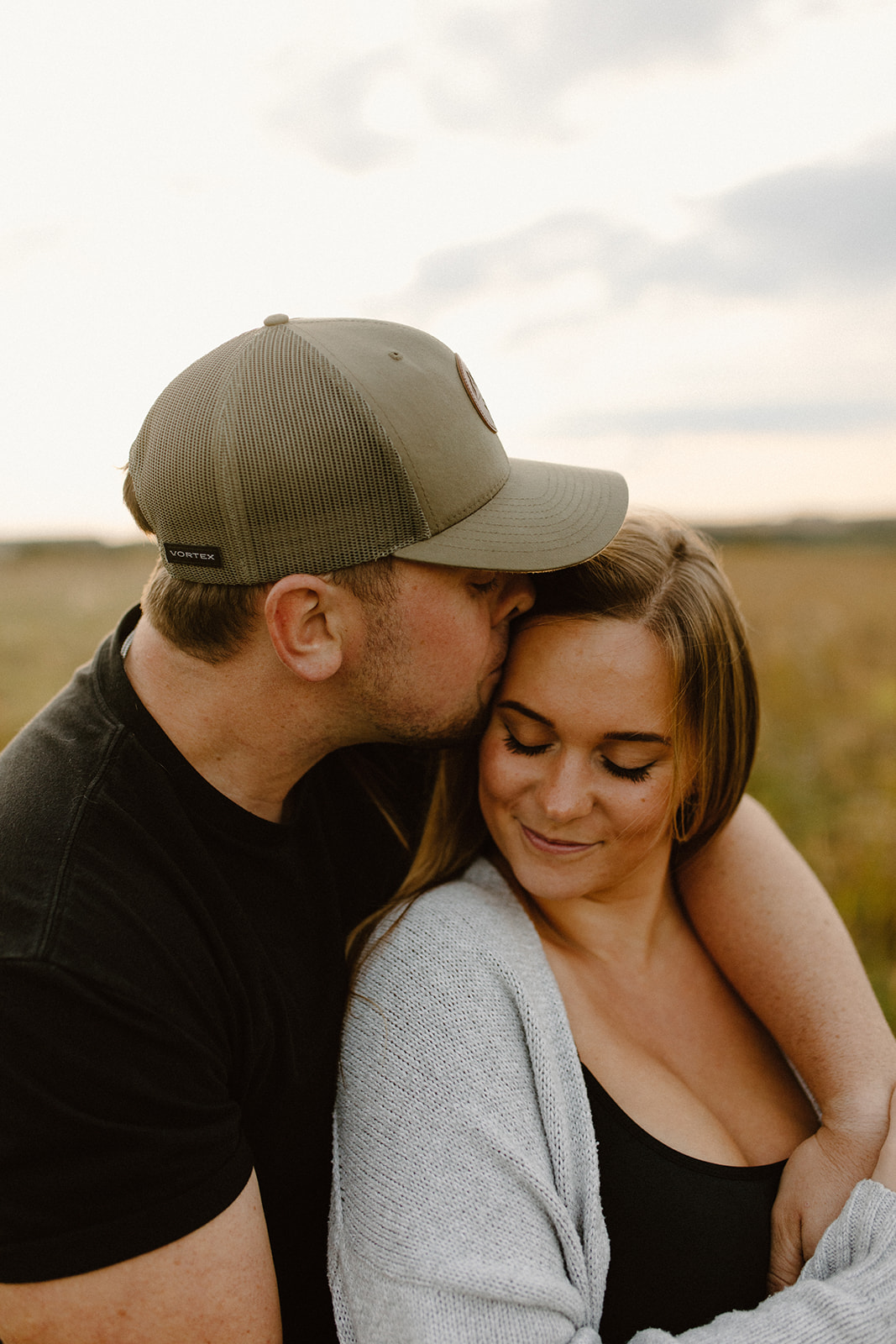 a couple in a grassy field at golden hour during a photo session in barneveld, wisconsin 