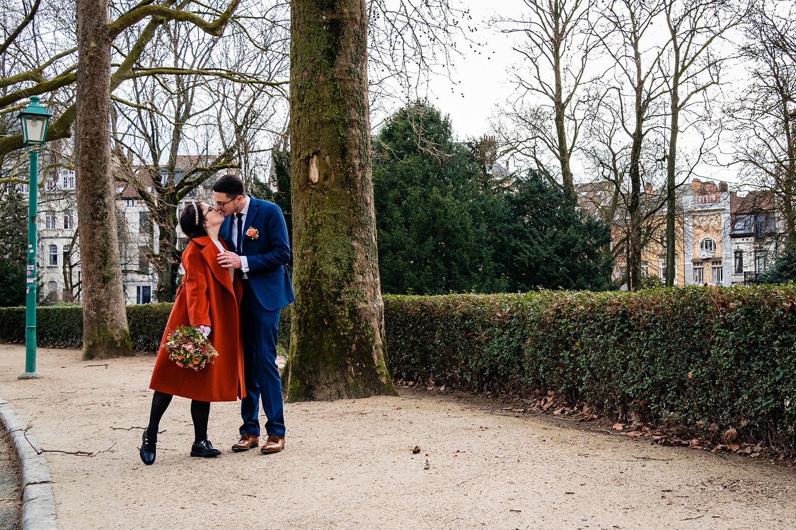 Dans le parc du cinquantenaire les mariés s'embrassant lors de la séance de photos de couple à Bruxelles