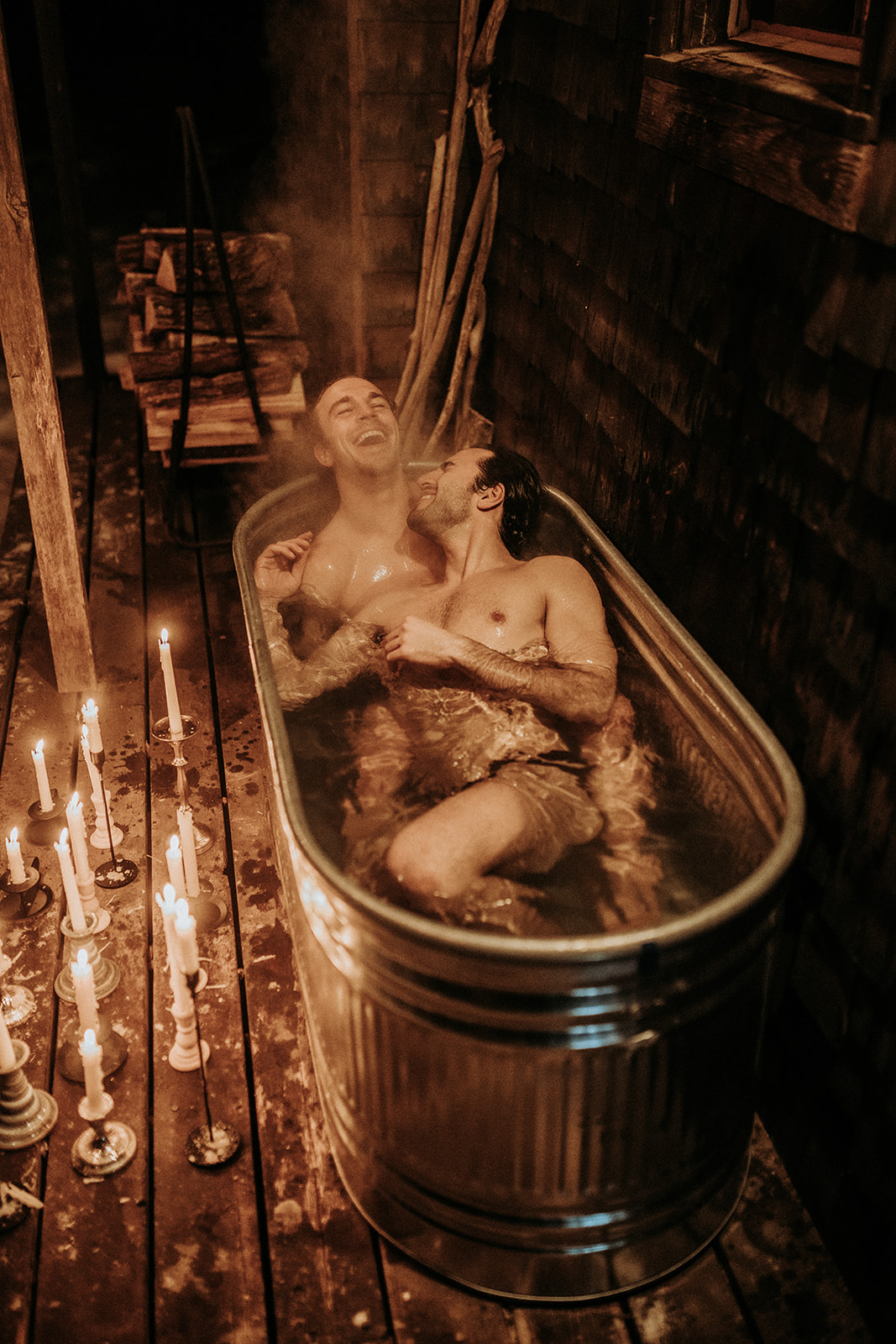 A gay couple laughing in a hot tub together.