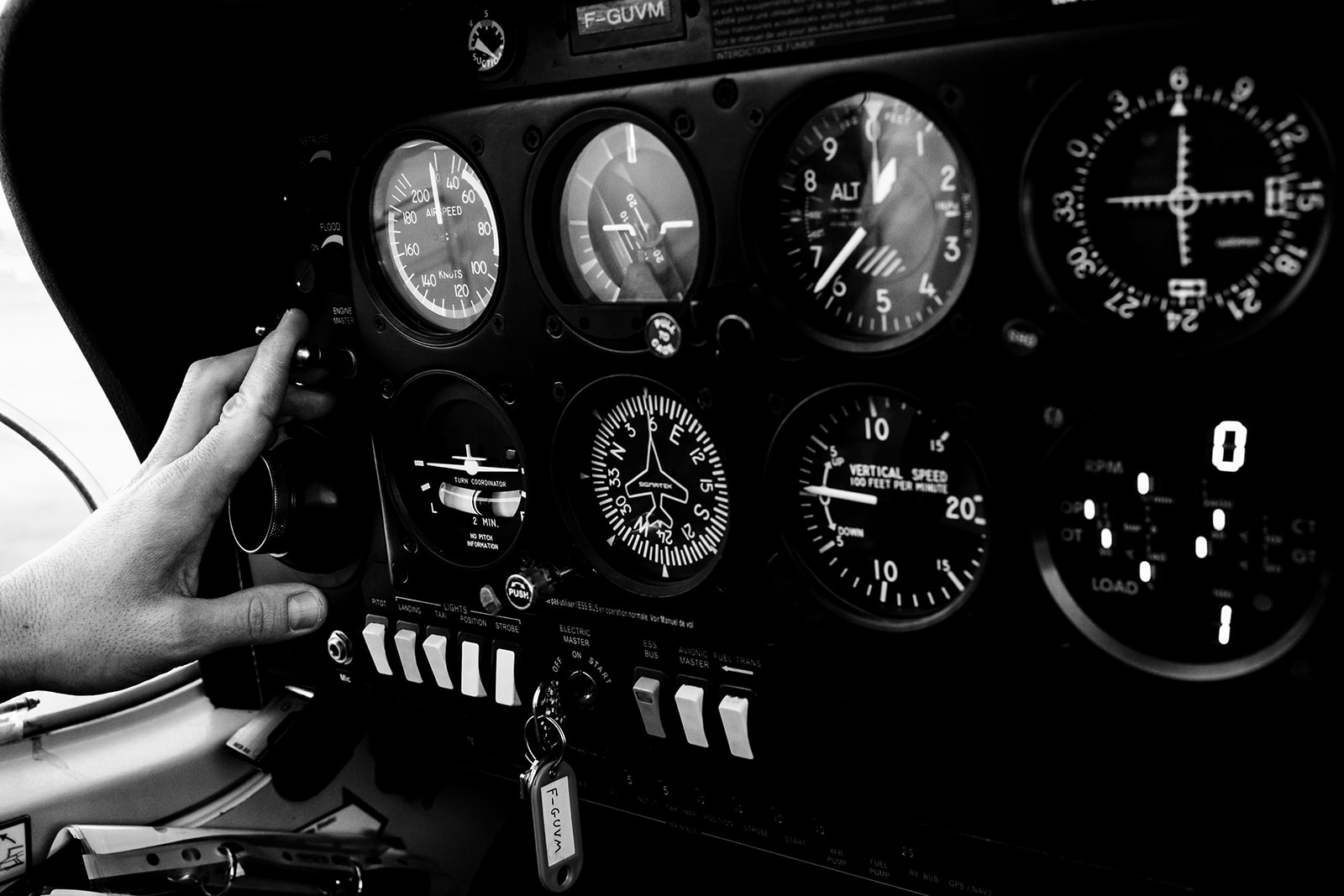 Vue d'un cockpit d'avion avec le doigt du pilote appuyant sur un bouton, photographe photo corporate Brabant Wallon