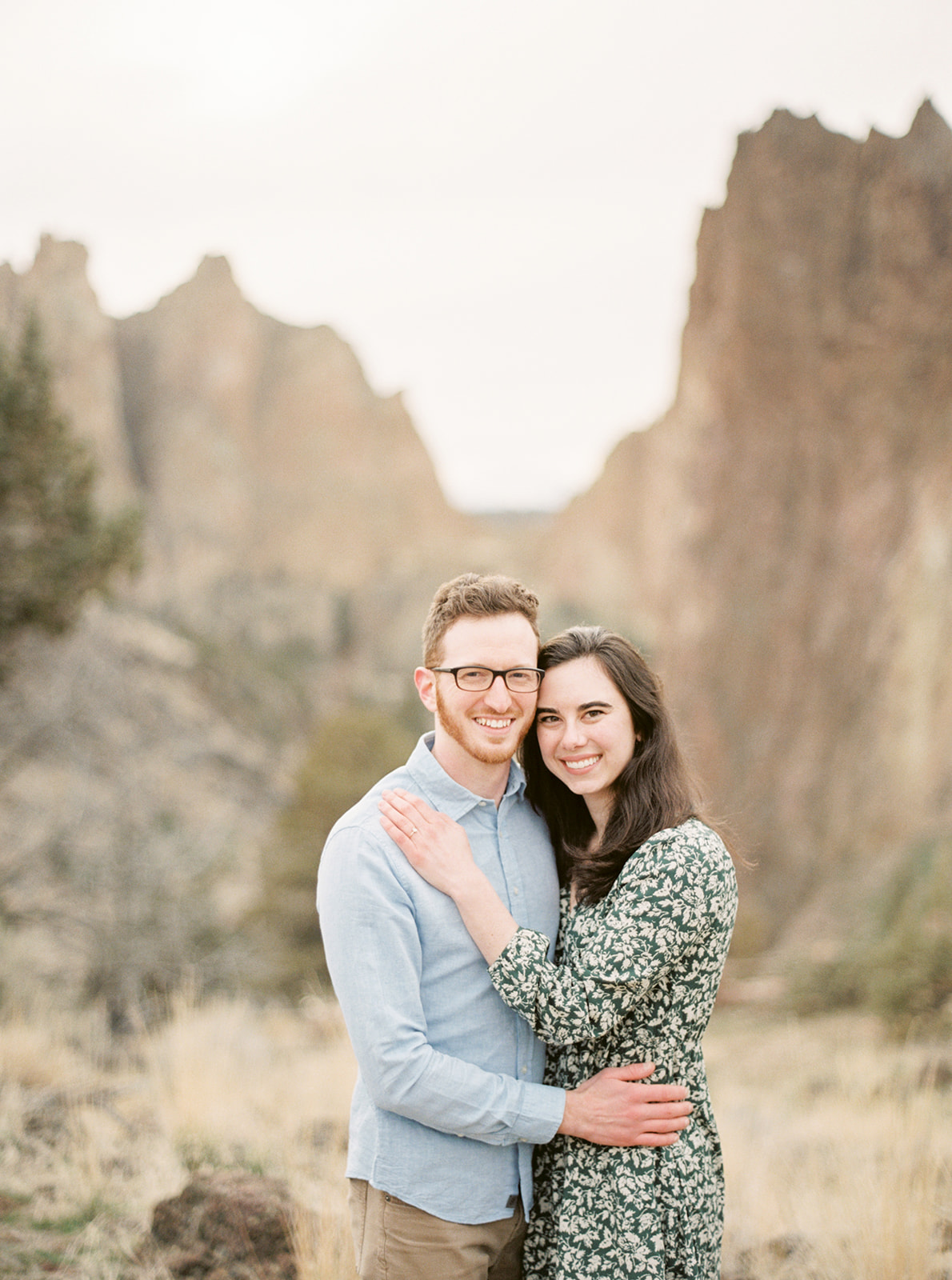 A couple smiles together while celebrating their engagement at Smith Rock