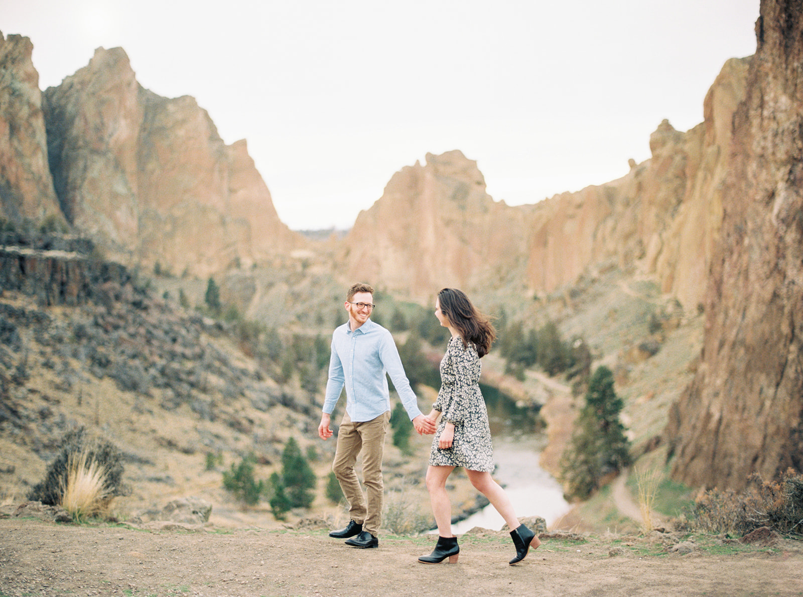 A couple enjoys their walk while dressed up for engagement photos in Bend, Oregon