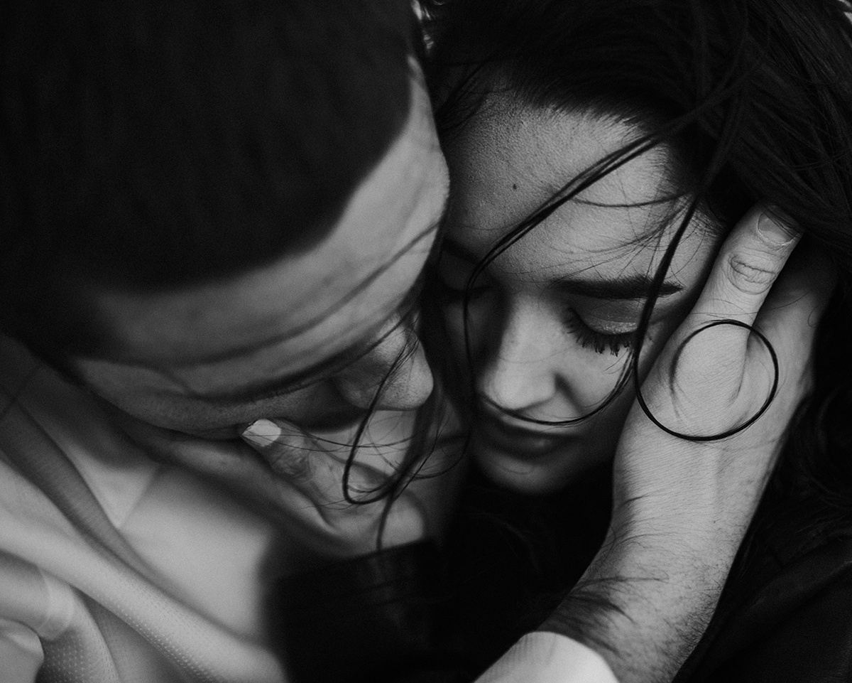 In a black and white close-up, two faces draw near, their intimacy amplified, encapsulating a profound, silent exchange 